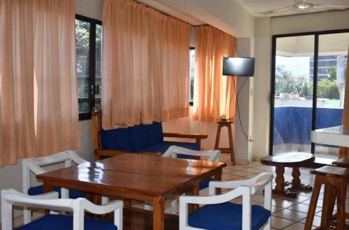 a living room with a table and chairs and a television at Suites Menavi in Acapulco