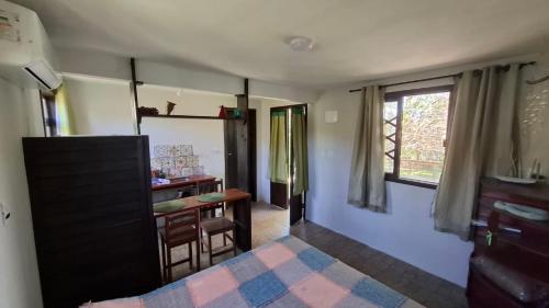 a room with a kitchen with a table and a window at Recanto dos Pássaros in Palhoça