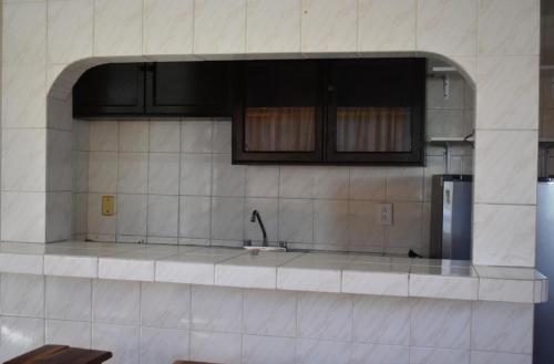 a kitchen with a sink and a refrigerator at Suites Menavi in Acapulco