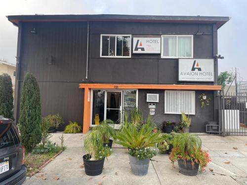 a black building with potted plants in front of it at AVAION HOTEL LAX SoFi STADIUM in Inglewood