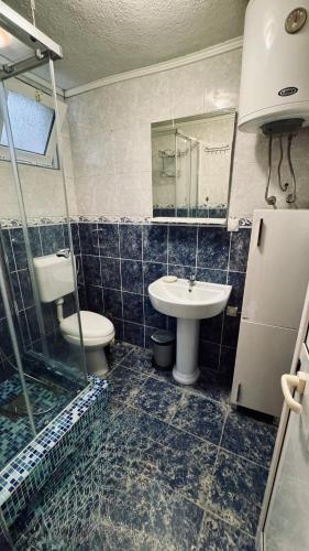 a bathroom with a sink and a toilet and a mirror at Apartmani Green Olive in Šušanj
