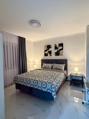 a bedroom with a large bed with two lamps and two tables at Comfort House Kocani in Kočani