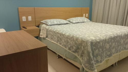 a bedroom with a large bed with a wooden headboard at Apartamento 2 quartos Mamelucos in Salvador