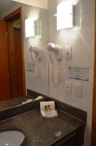 a bathroom with a sink and a mirror at Hotel Áster in Alagoinhas