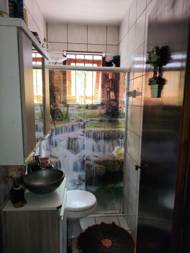 a bathroom with a shower and a sink with a waterfall at Família Jardim in São Gabriel