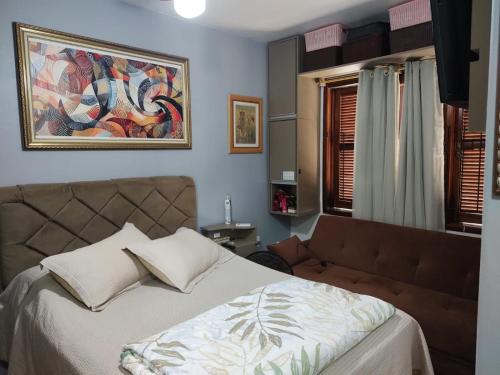 a bedroom with a bed and a painting on the wall at Família Jardim in São Gabriel