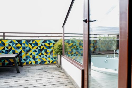 a balcony with a tub and a mosaic wall at Hotel Opera in Madrid
