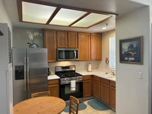 a kitchen with a stainless steel refrigerator and a table at The Mahogany Shore in Oceano