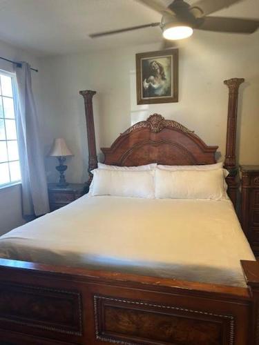 a bedroom with a wooden bed with a ceiling fan at The Mahogany Shore in Oceano