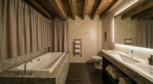 La grande salle de bains est pourvue d'une baignoire et de toilettes. dans l'établissement Elegance Home, à Cortina dʼAmpezzo