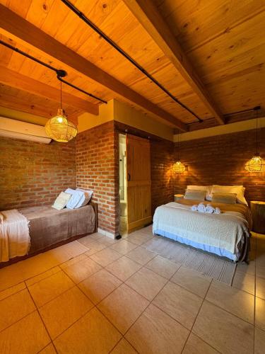 a bedroom with two beds and a brick wall at Amambay in Puerto Bossetti