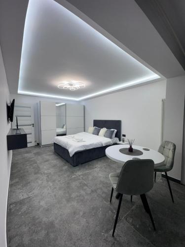 a bedroom with a bed and a table and chairs at Grey Serenity in Brăila