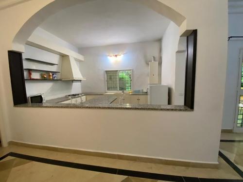 a large kitchen with a large white wall at Appartement Domaine Du Soleil Hammamet 