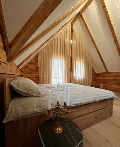 a bedroom with a bed with candles on a table at Green District - Riverside Luxury Lodge in Banja Luka