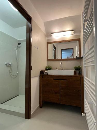 a bathroom with a sink and a shower with a mirror at Chata Dolce Donovaly in Donovaly