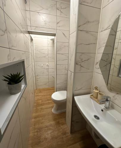 a white bathroom with a toilet and a sink at Green District - Riverside Luxury Lodge in Banja Luka