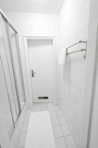a white bathroom with a shower and a white door at Munich Premium Guesthouse in Munich