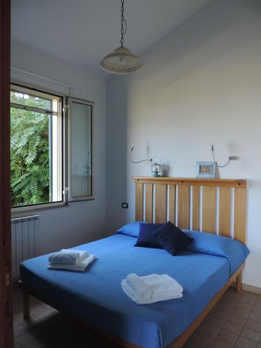 a bedroom with a blue bed with two towels on it at Agriturismo Sila in Termoli