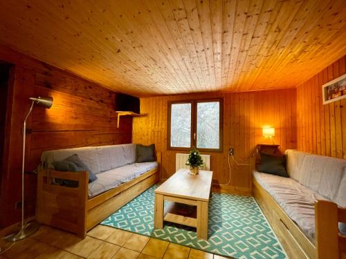 un salon avec deux canapés et une table dans l'établissement CHARMIEUX appartement en chalet typique, au Grand-Bornand