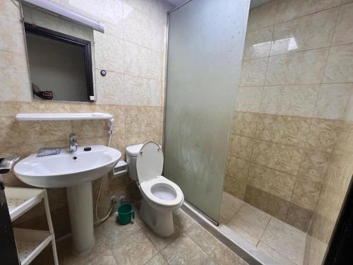 a bathroom with a toilet and a sink and a shower at عجمان المويهات 2 Ajman in Ajman