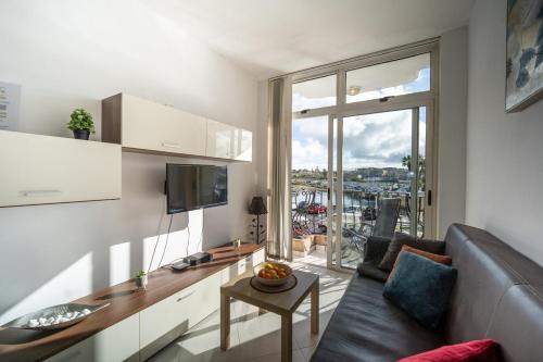 a living room with a couch and a large window at Silver Harbour - 2 Bedrooms, 2 Bathrooms in Il-Gżira