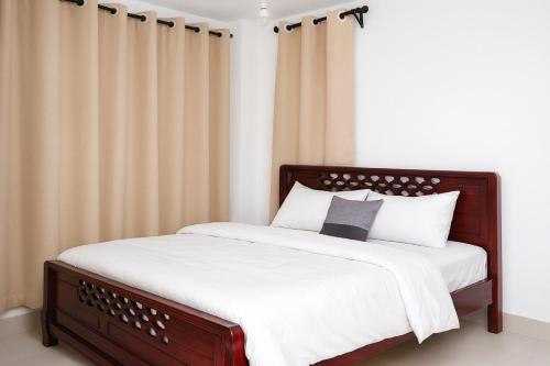 une chambre avec un lit avec des draps blancs et des oreillers dans l'établissement Lakeview Luxe Haven, à Kisumu