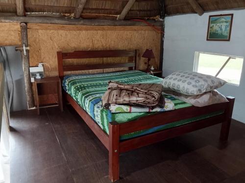 una camera da letto con un letto con un piumone verde di Palafito ad Aguas Dulces