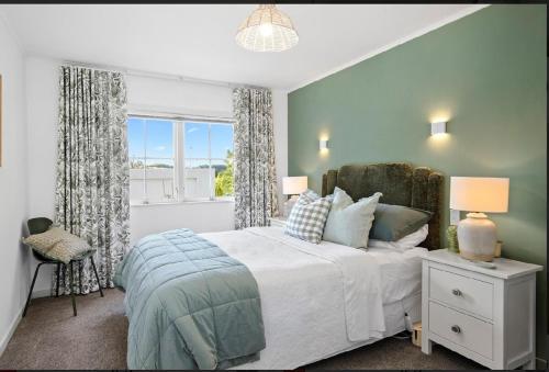 een slaapkamer met een groot bed en een raam bij Kowhai Apartment-Ground Floor in Pukekohe East