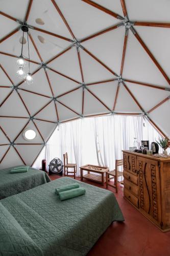 a room with two beds in a large tent at Aldea Hualtepec Glamping in Huichapan