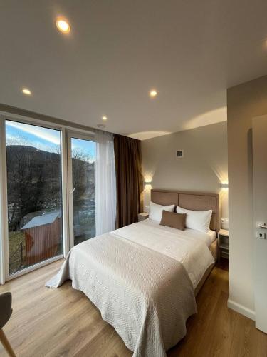 a bedroom with a large bed and a large window at Tatariv-hills in Tatariv