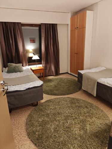 a hotel room with two beds and two rugs at Patomajat in Rovaniemi