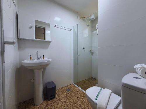 a bathroom with a toilet and a sink and a shower at Cataratas Loft Residence in Foz do Iguaçu