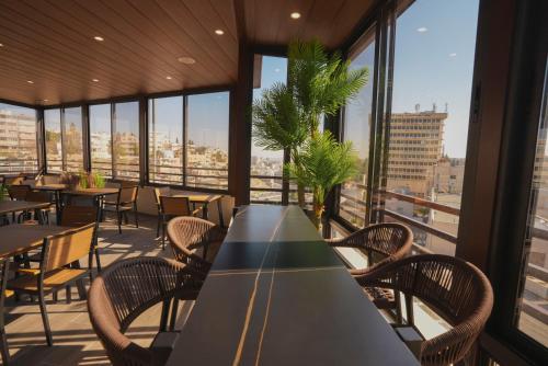 a conference room with a table and chairs and windows at Friends Hotel Jordan in Amman