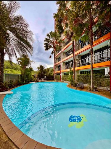 a large blue swimming pool in front of a building at Bright Sun Apartment with Pools in Rawai Beach