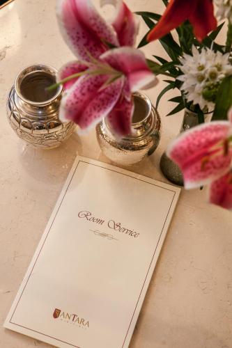 a card on a table with flowers and vases at Antara Hotel & Suites - Miraflores in Lima