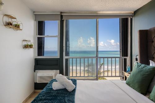 una camera da letto con un letto e vista sull'oceano di Punta Arenas 1BDR Oceanfront Pool Parking a San Juan