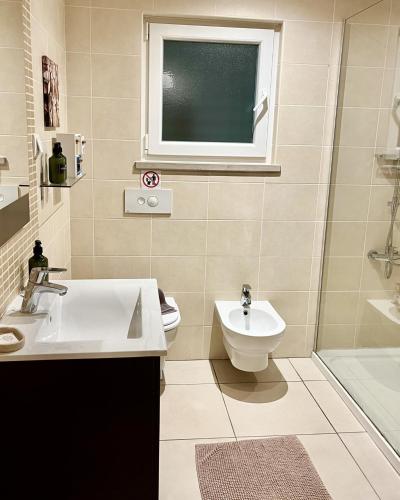 a bathroom with a sink and a toilet and a window at Casas do Mar - Baleal 1 - Sea House in Baleal