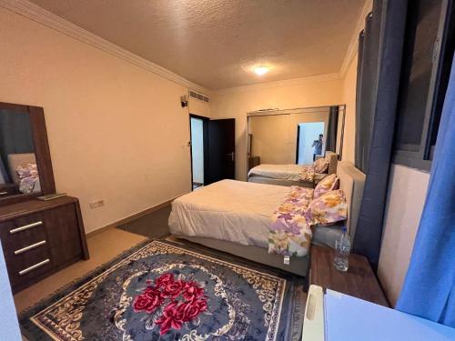 a bedroom with two beds and a table with a mirror at عجمان المويهات 2 Ajman in Ajman