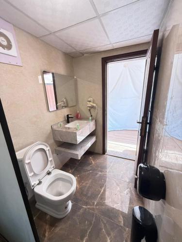 a bathroom with a toilet and a sink and a tub at Sunrise Luxury Camp in Wadi Rum
