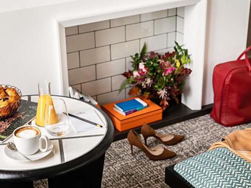 een salontafel met een kop koffie en schoenen bij Sofitel Le Scribe Paris Opera in Parijs