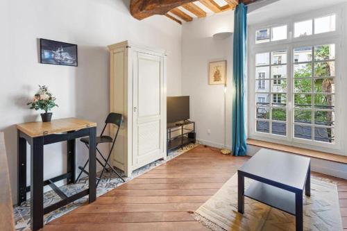 een woonkamer met een tafel en een bureau bij cœur du Bouffay in Nantes