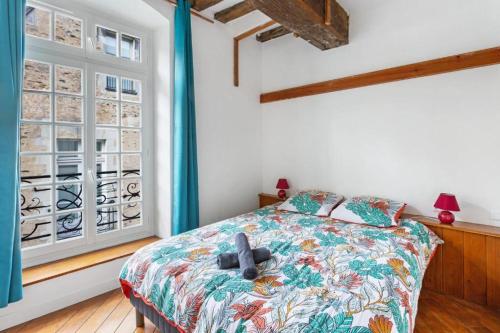 a bedroom with a bed and a window at cœur du Bouffay in Nantes