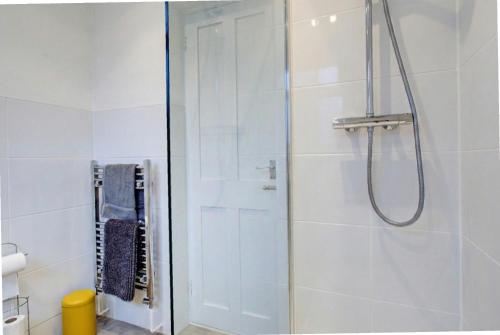 una doccia con una porta in vetro in un bagno di Colchester CntrCosyOfficePatioTrainParkPet a Colchester