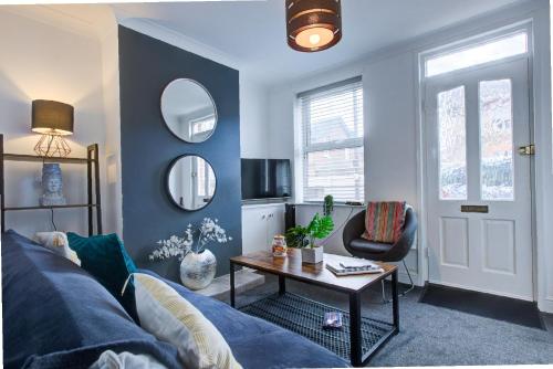 a living room with a blue couch and a table at Pet-Friendly Victorian, Free Parking, Workspace in Colchester