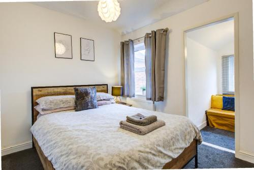 una camera da letto con un letto grande e una finestra di Colchester CntrCosyOfficePatioTrainParkPet a Colchester