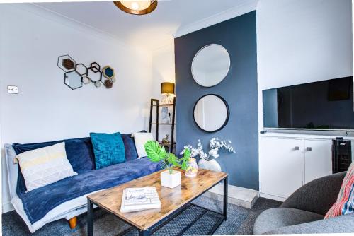a living room with a blue couch and a table at Pet-Friendly Victorian, Free Parking, Workspace in Colchester