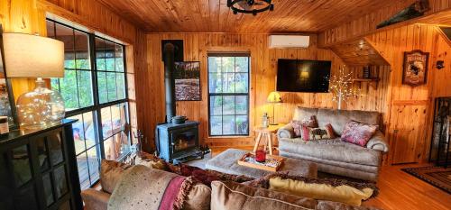 een woonkamer met een bank en een fornuis bij Cliffside Cabin at Piney Falls - with Creek Access 