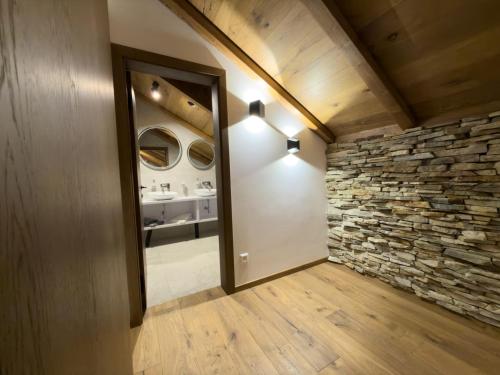 ein Badezimmer mit einer Steinmauer und einem Spiegel in der Unterkunft Vila Vento in Veľký Slavkov