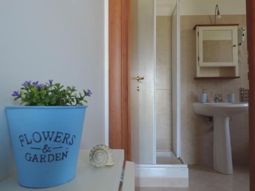 a bathroom with a plant in a blue trash can at Agriturismo Sila in Termoli