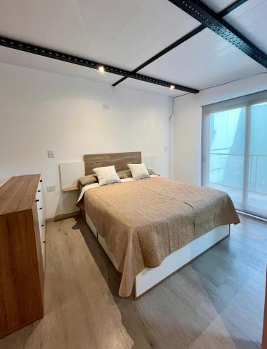 a bedroom with a large bed and a large window at Moderno DEPARTAMENTO temporal SAN JORGE in San Jorge